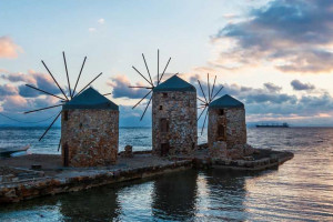 Panorama de la puesta de sol de cuatro molinos en el mar de la isla de Chios